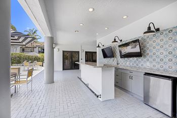 covered outdoor kitchen with TVs